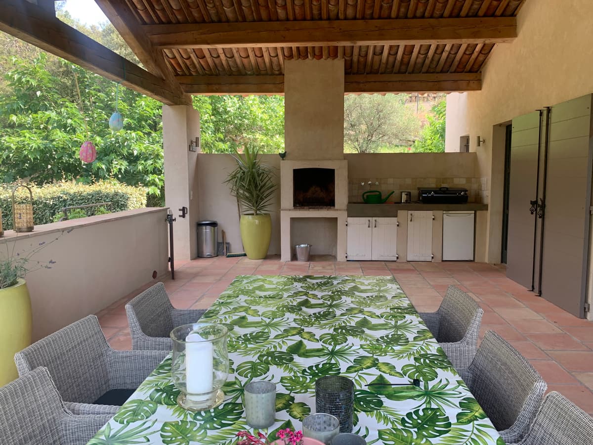 Cuisine d'été couverte avec barbecue et grande table à manger
