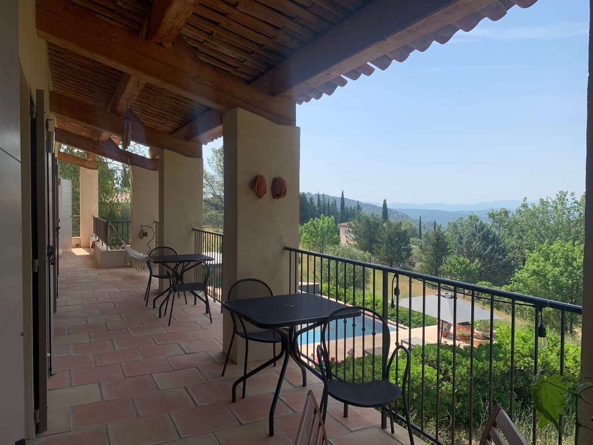 Überdachte Terrasse mit Blick über den Pool und die Hügel